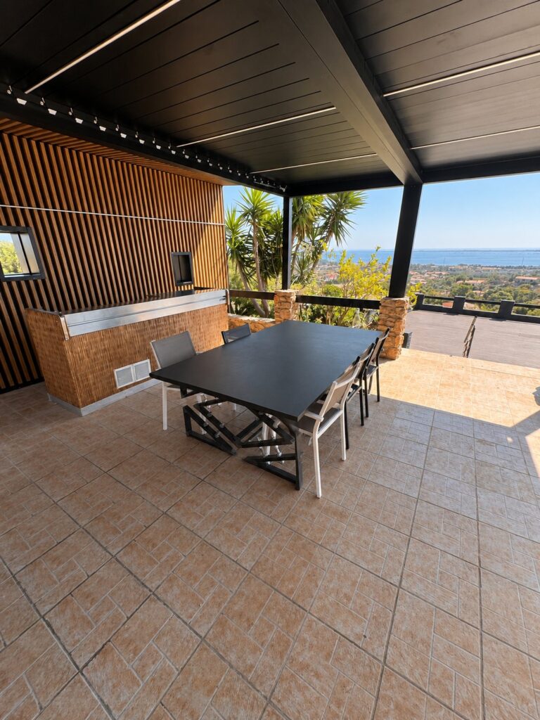 L’intérieur de la pergola bioclimatique, avec des bandeaux lumineux intégrés entre les lames d’aluminium