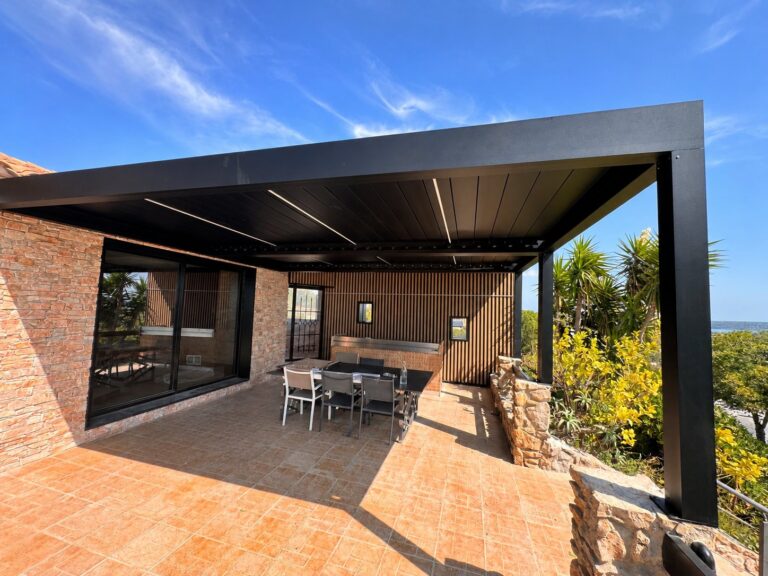 La structure en aluminium de la pergola bioclimatique, adossée à la façade, avec des poteaux sur le côté extérieur